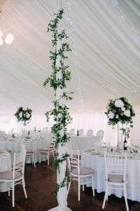 Hire marquee in Perthshire with centre-poles decorated with flowers to add to the wedding theme