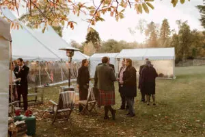 Guests gather outside the winter wedding marquee for a chat