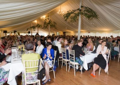 wedding guests eating at tables in a wedding marquee hire