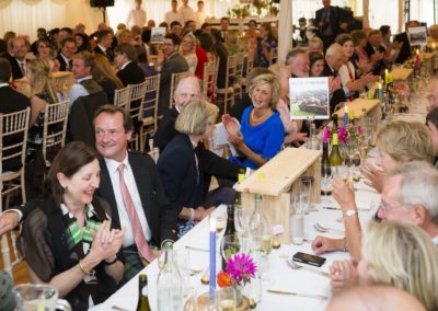 Guests sitting at tables enjoying the speaches in a new century marquee hire