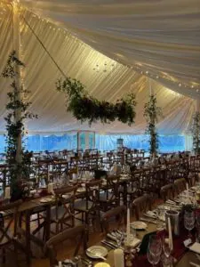 Elegant marquee wedding reception with draped ceiling, fairy lights, and floral centrepieces at Gilmerton House.
